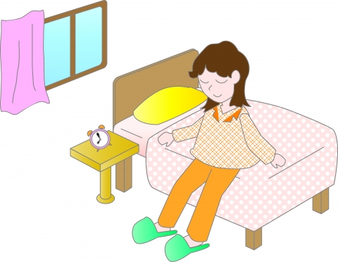 パジャマ姿でベッドに座っている女性のイラスト